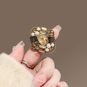Vintage gold statement ring with amber stone, pearls and crystals on elegant hand