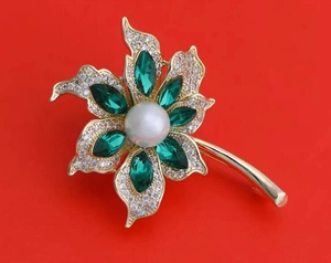 Détail de la broche cocotier avec pierres marquises vertes et perle sur base dorée