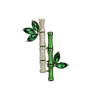 Macro shot of bamboo brooch with green crystal stones and sparkling white zircons