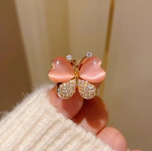 Détail macro d'une bague papillon avec des pierres œil-de-chat roses et zircons