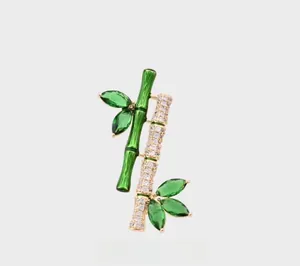 Macro shot of bamboo brooch with green enamel leaves and micro-paved zircons