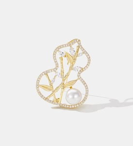 Macro shot of gold gourd brooch with bamboo leaf motifs, micro-diamonds and a white pearl