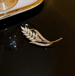 Vue détaillée d'une broche en forme de blé doré avec feuilles d'opale et strass brillants