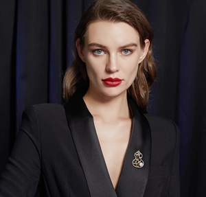 Detail of a golden gourd brooch with bamboo leaves and pearl on a black suit lapel