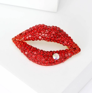Détail de la broche lèvres en strass rouges avec accent diamant blanc et base dorée