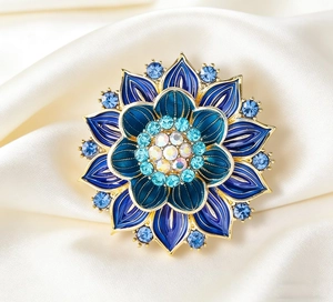 Macro detail of luxury blue enamel lotus brooch with gold petals and sparkling crystal center