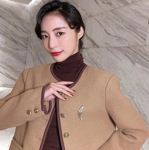 Détail macro d'une broche en forme d'épi de strass sur une veste en tweed beige élégante
