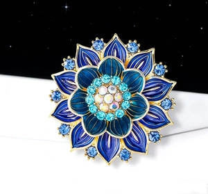 Macro detail of luxury lotus brooch with blue enamel petals and crystal embellishments