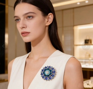 Detailed close-up of a luxury blue enamel lotus flower brooch pinned on a white blouse