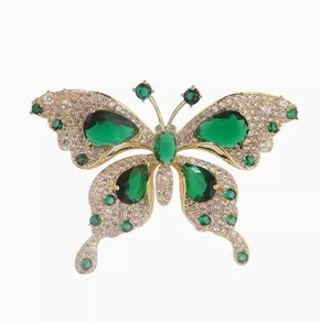 Detail view of butterfly brooch with emerald green crystals and micro-pave white zircons