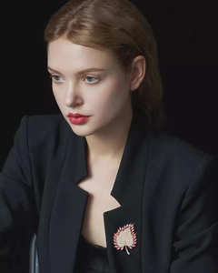 Close-up of maple leaf brooch with pink crystal gemstones on a black suit lapel
