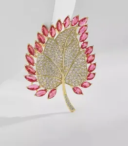 Detailed macro view of the luxury maple leaf brooch with pink gems and white crystals