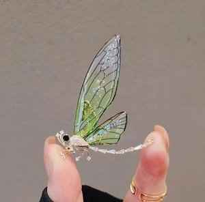 Macro shot of green dragonfly brooch wings with sparkling zircon stone accents