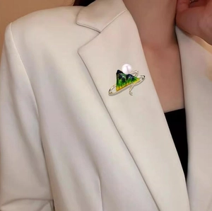 Elegant gold enamel landscape brooch with pearl and zircons on white blazer