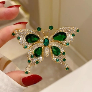 Elegant emerald butterfly brooch in gold finish with sparkling zircon and green stones