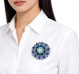 Detail of elegant lotus flower brooch with blue gradient enamel and crystals on a model