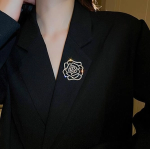 Détail d'une broche fleur en strass scintillants sur le revers d'une veste noire