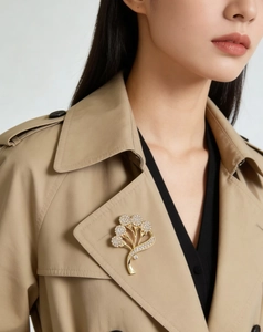 Élégante broche fleur dorée avec cristaux blancs sur le revers d'un trench-coat classique