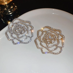 Vue macro détaillée de broches camélia dorées et argentées avec des strass étincelants
