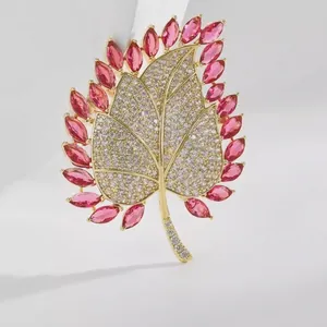 Elegant maple leaf brooch with pink and clear crystals on a premium gold-plated base
