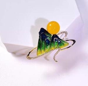 Detail of green enamel landscape brooch with yellow pearl and sparkling crystals