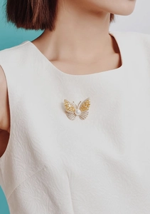 Detailed close-up of a luxury butterfly brooch with gold and silver zircon inlay