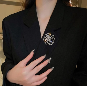Détail d'une broche fleur scintillante sertie de diamants sur le revers d'un blazer noir