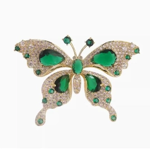 Elegant emerald green butterfly brooch in gold-plated finish with sparkling white zircons