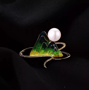 Detail of green enamel mountain brooch with large white pearl and zircon inlay