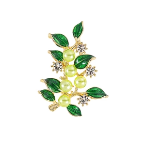 Eleganter goldener Zweig-Anstecknadel mit grünen Blättern und Perlen auf weißem Grund
