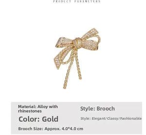 Close-up of golden bow brooch with sparkling crystal rhinestones and rope texture
