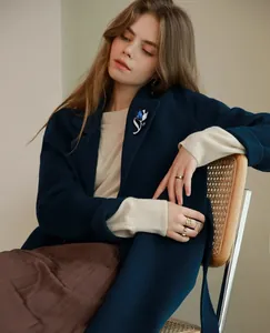 Deep blue crystal tulip brooch styled on a navy wool coat for a luxury winter look