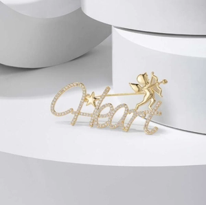 Close-up of golden Heart brooch with sparkling rhinestones and Cupid detail