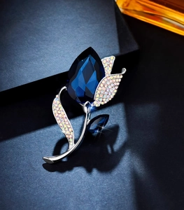 Macro shot of tulip brooch with dark blue crystal and silver leaf detailing