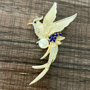 Golden phoenix bird brooch with white pearls, blue gemstones and sparkling crystals