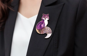 Close-up of elegant purple fox brooch with crystal inlay on a black blazer lapel