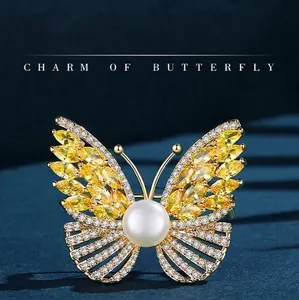 Elegant gold butterfly brooch with yellow marquise zircons and a white pearl accent