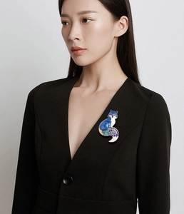 Detail of elegant fox brooch with blue enamel and gradient rhinestones on a blazer