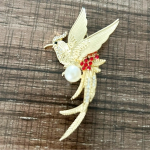 Elegant gold phoenix bird brooch with sparkling rhinestones and white pearl accent