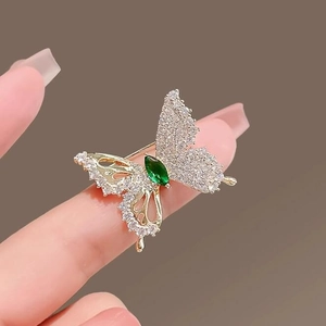Elegant gold butterfly brooch with sparkling green gemstone and white zircon stones