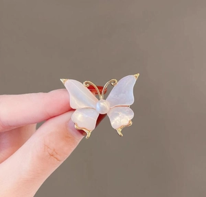 Close-up of vintage butterfly brooch with mother of pearl wings and a center pearl inlay