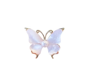 Detailed close-up of a vintage butterfly brooch with pink pearlescent wings and white pearl