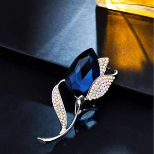 Elegant Calla Lily brooch with deep blue faceted crystal and silver-toned sparkling rhinestones