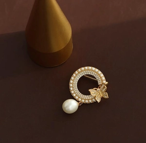 Broche papillon dorée élégante avec cristaux scintillants et perle de goutte d'eau