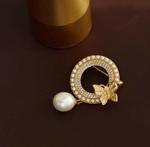 Détail de la broche papillon élégante avec perles et pendentif en forme de larme
