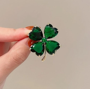 Exquisite four-leaf clover brooch with emerald green crystals and golden metal frame