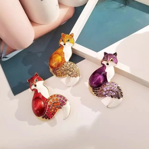 Detail of fox brooches with colorful enamel finish and crystal-encrusted tails