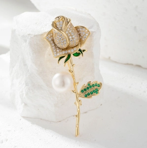 Elegant gold rose brooch with sparkling crystals and a large white pearl centerpiece