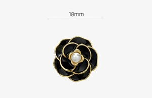 Detailed view of 18mm black camellia brooch pin with gold edges and pearl center