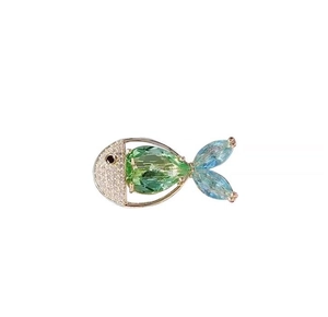 Makroaufnahme der Fischbrosche mit grünem Edelstein und blauem Kristallschwanz